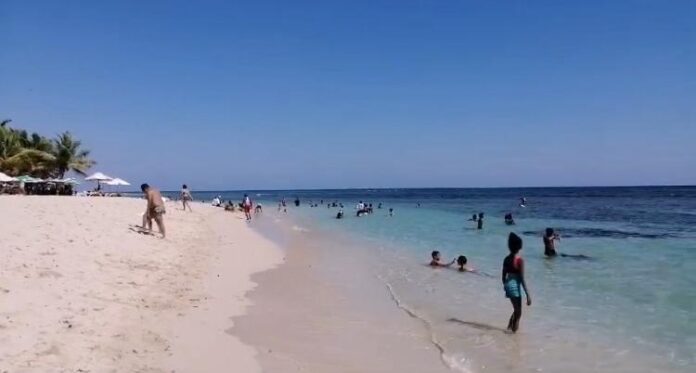 Bañistas comienzan a llegar a playa Juan Dolio en la tarde de este jueves.